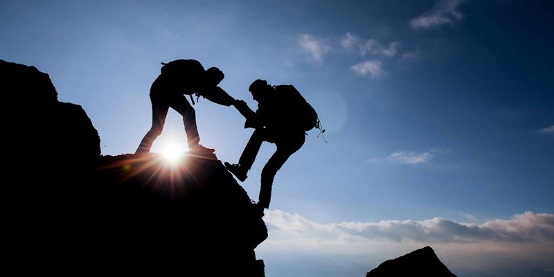 team-work - 2 climbers assisting each other